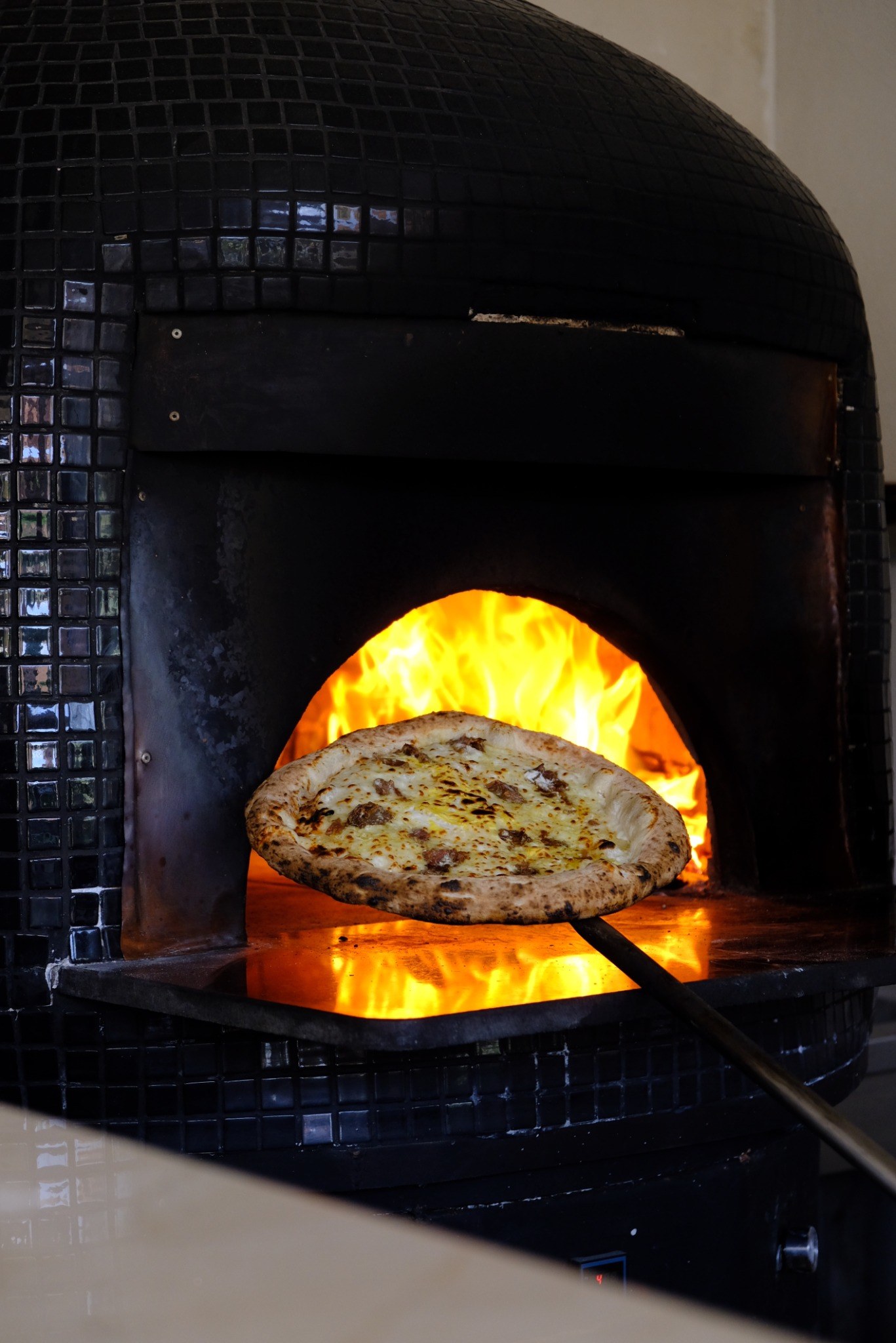 Pizza cuite au feu de bois sortant du four de Carmel Marrakech
