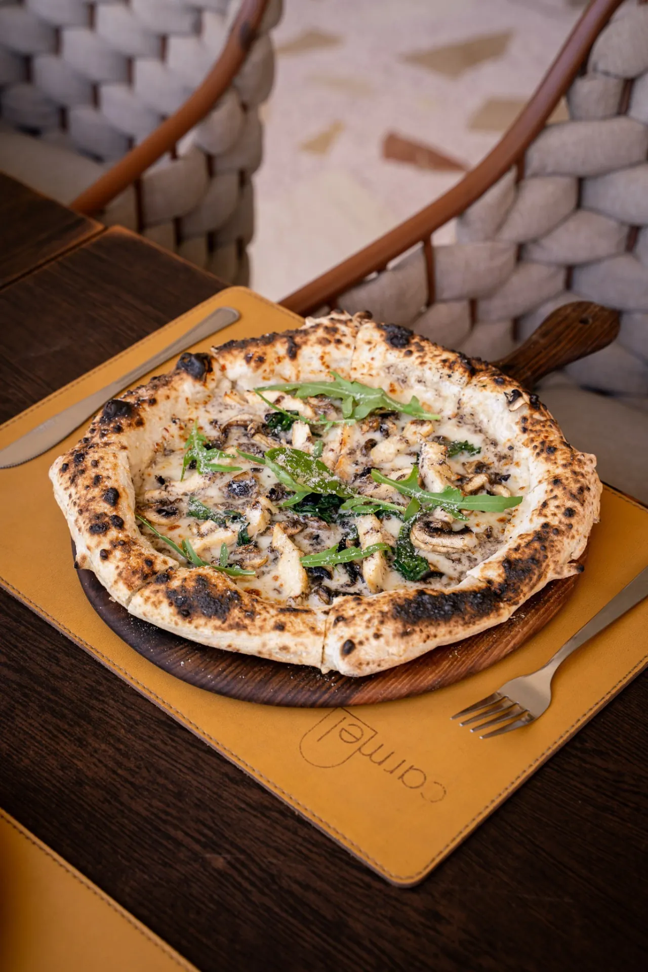 Pizza au feu de bois garnie de champignons et de roquette