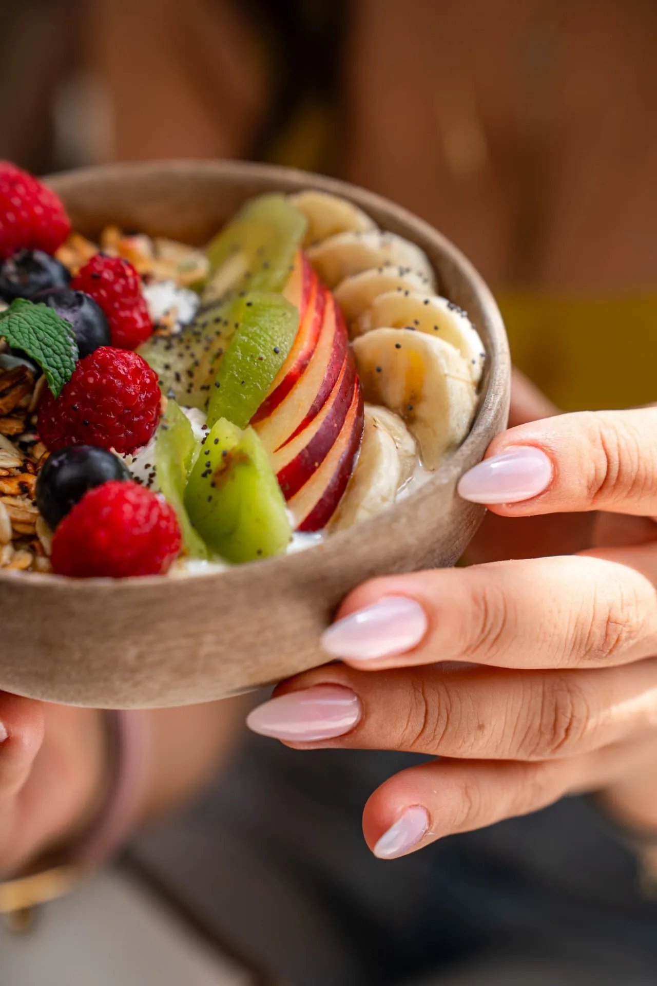 Fresh fruit bowl with raspberries, blueberries, apple, kiwi and banana