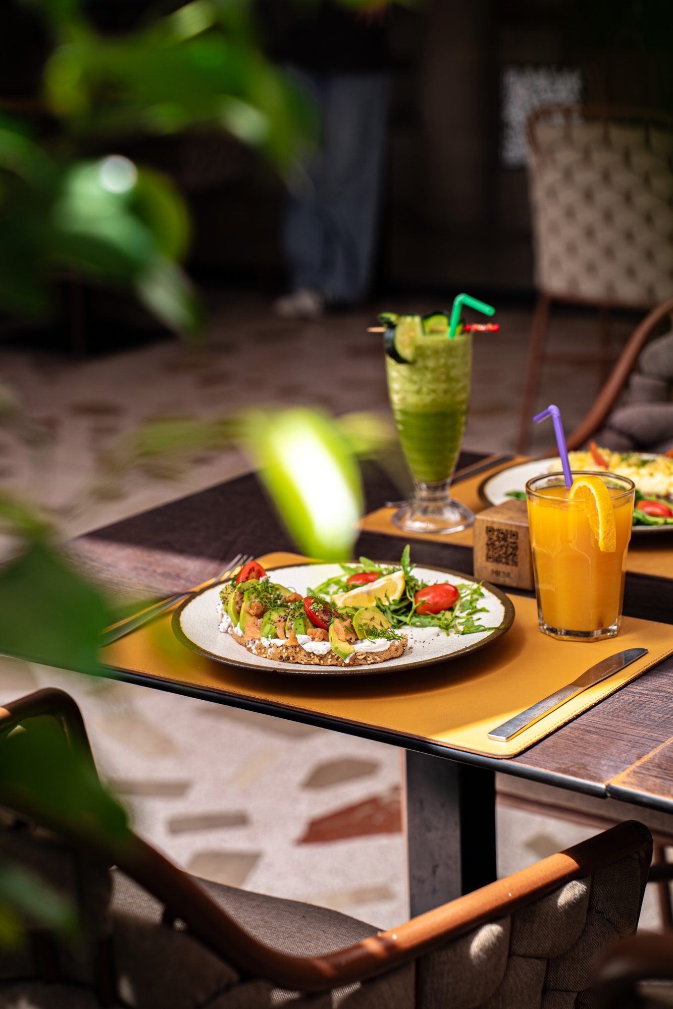 Jus d'orange frais et smoothie vert sur la terrasse du jardin